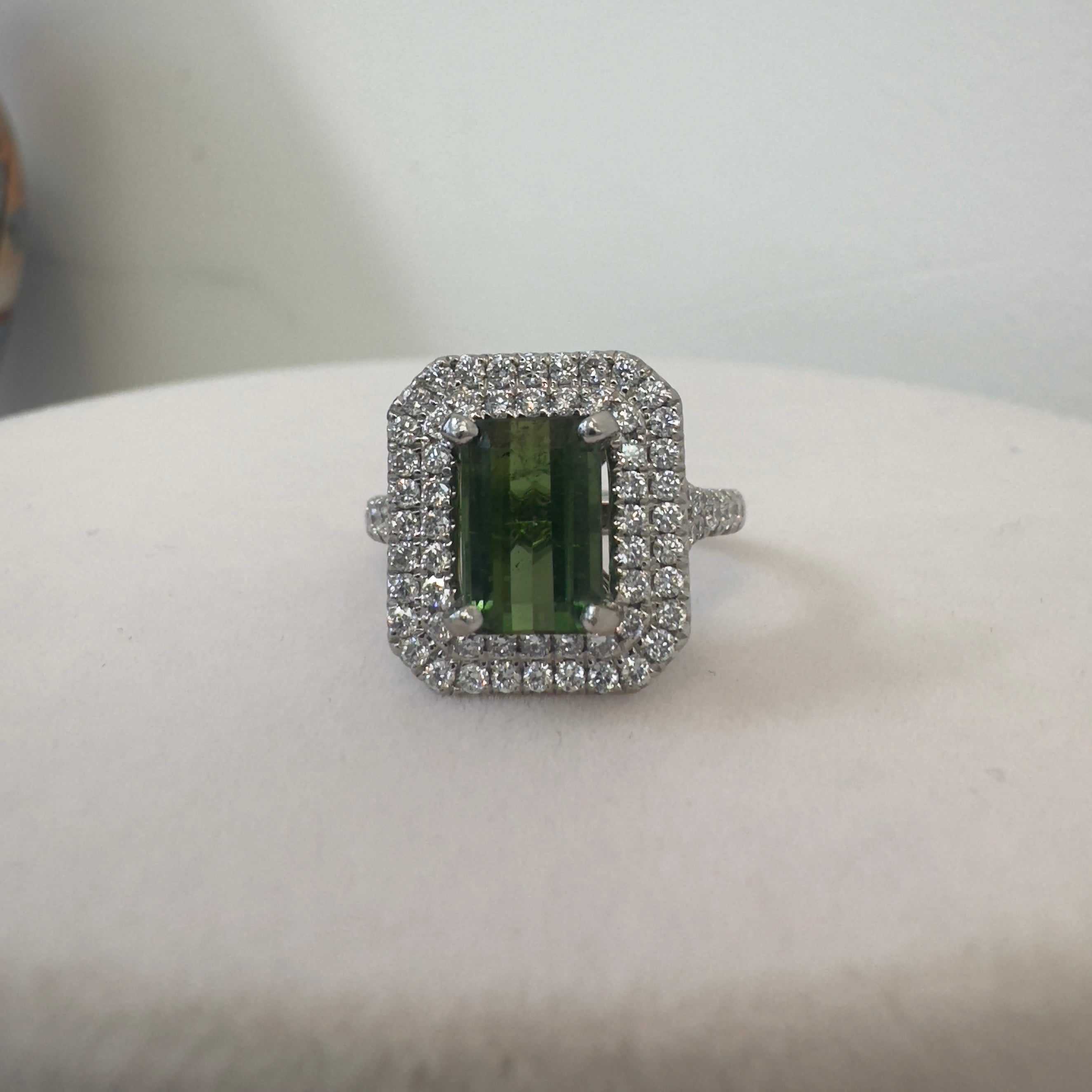 טבעת משובצת אבן גרנט ירוקה מרכזית כ2.20 קראט עם שיבוץ היילו יהלומים טבעיים כפול 0.80 קראט צבע F ניקיון VS זהב 18K לבן מק״ט 696