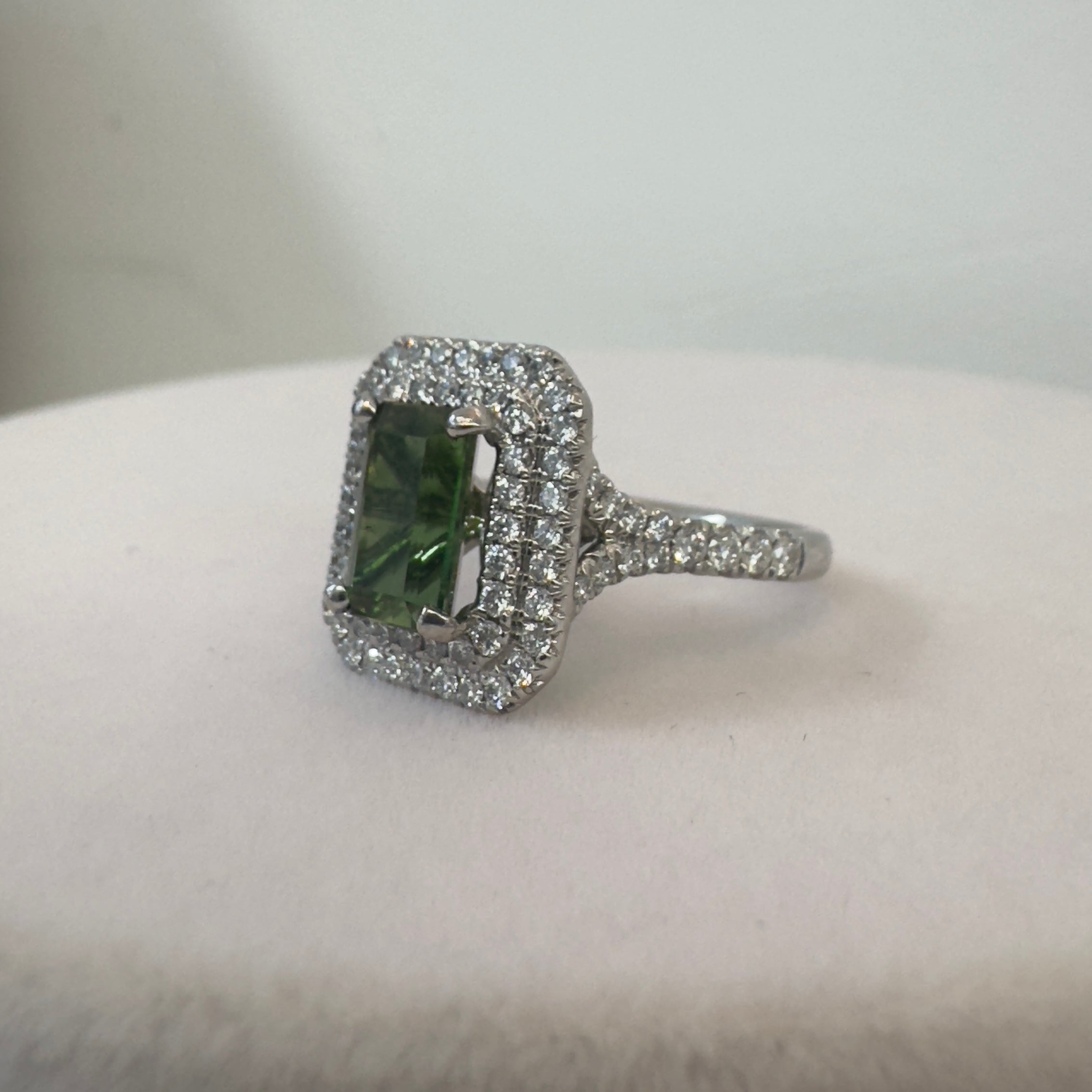 טבעת משובצת אבן גרנט ירוקה מרכזית כ2.20 קראט עם שיבוץ היילו יהלומים טבעיים כפול 0.80 קראט צבע F ניקיון VS זהב 18K לבן מק״ט 696