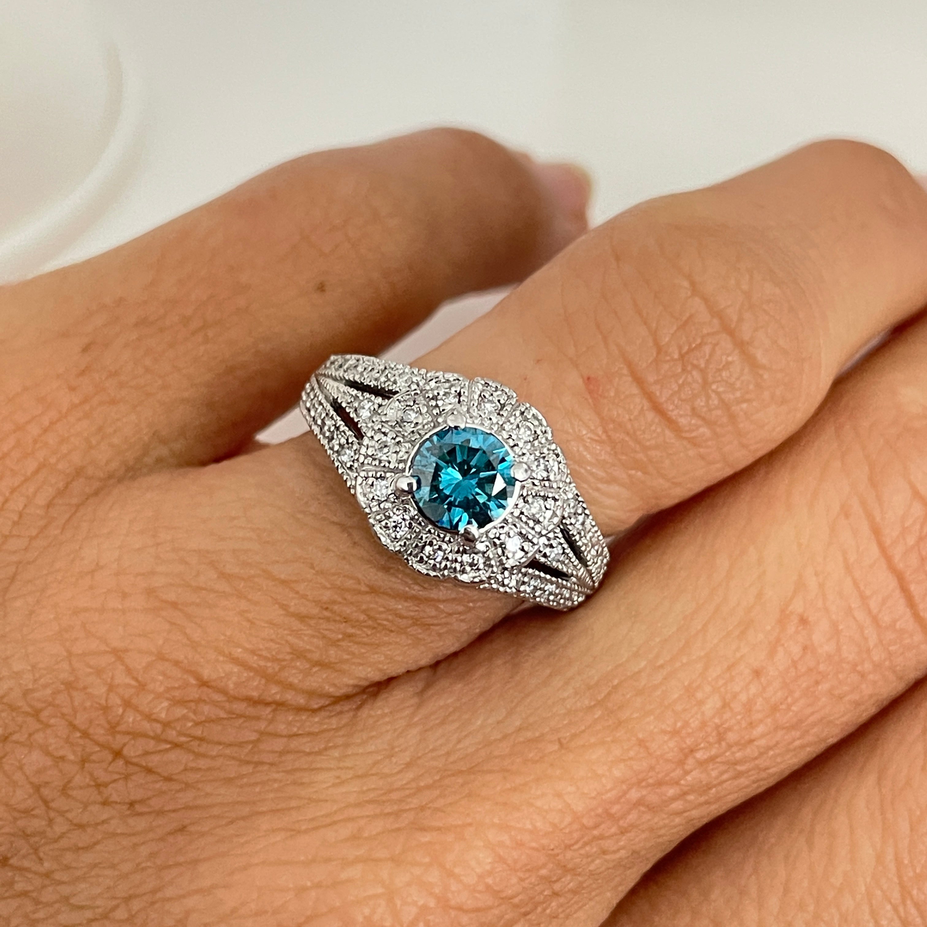 טבעת יהלום כחול צבוע טבעי 0.80 קראט ניקיון VS בשיבוץ היילו יהלומים טבעיים 0.40 קראט בעיצוב פרח צבע F ניקיון VS זהב 14K לבן מק"ט 535