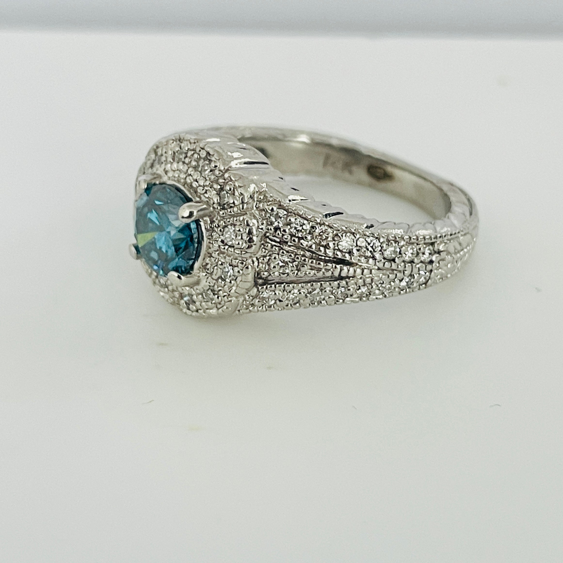 טבעת יהלום כחול צבוע טבעי 0.80 קראט ניקיון VS בשיבוץ היילו יהלומים טבעיים 0.40 קראט בעיצוב פרח צבע F ניקיון VS זהב 14K לבן מק"ט 535