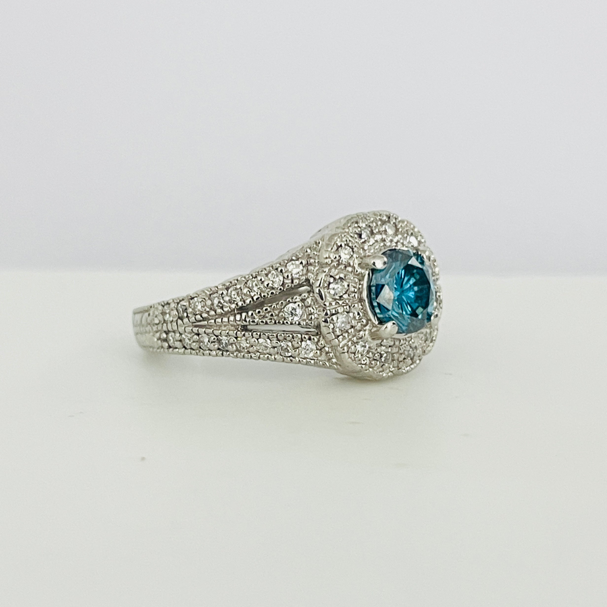 טבעת יהלום כחול צבוע טבעי 0.80 קראט ניקיון VS בשיבוץ היילו יהלומים טבעיים 0.40 קראט בעיצוב פרח צבע F ניקיון VS זהב 14K לבן מק"ט 535