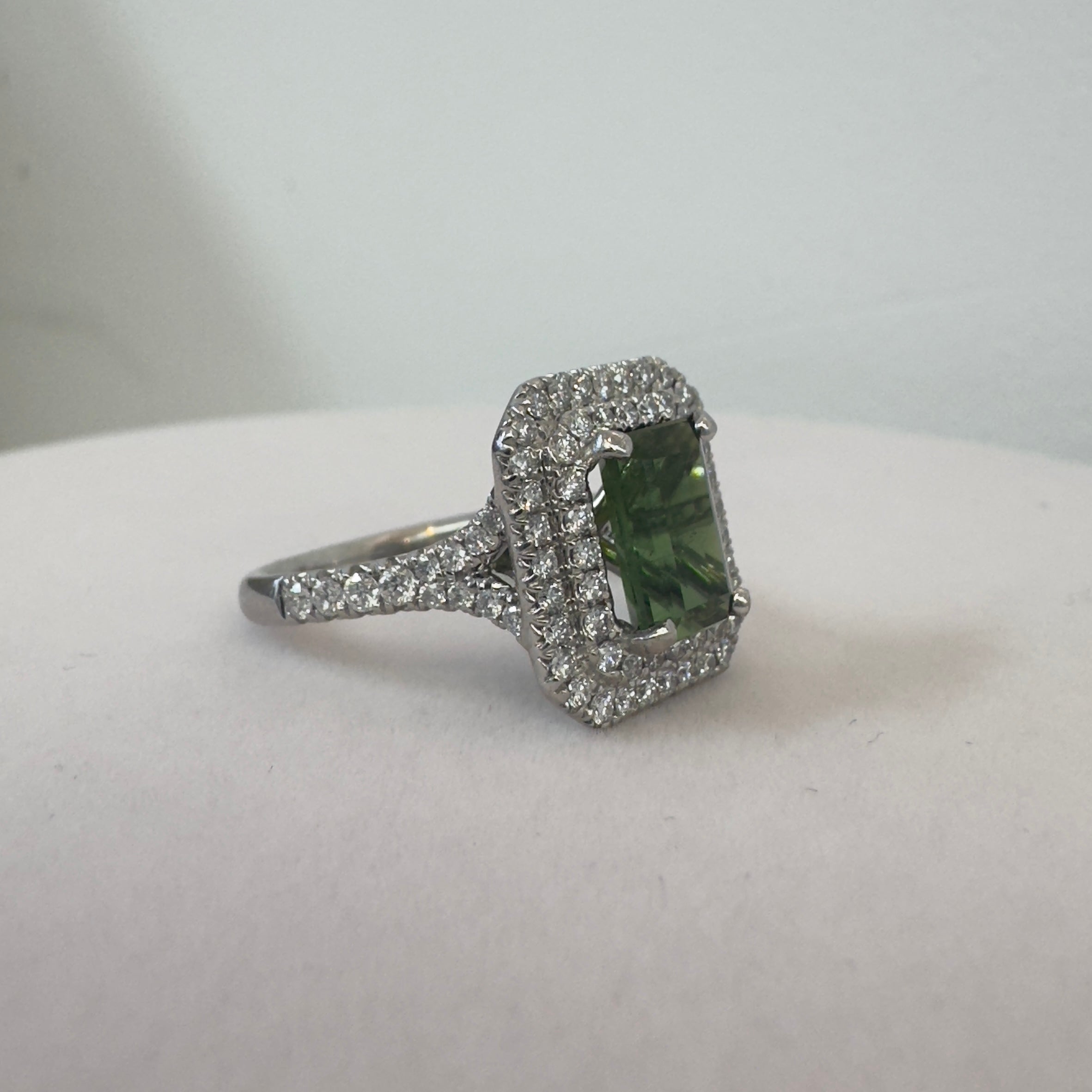 טבעת משובצת אבן גרנט ירוקה מרכזית כ2.20 קראט עם שיבוץ היילו יהלומים טבעיים כפול 0.80 קראט צבע F ניקיון VS זהב 18K לבן מק״ט 696